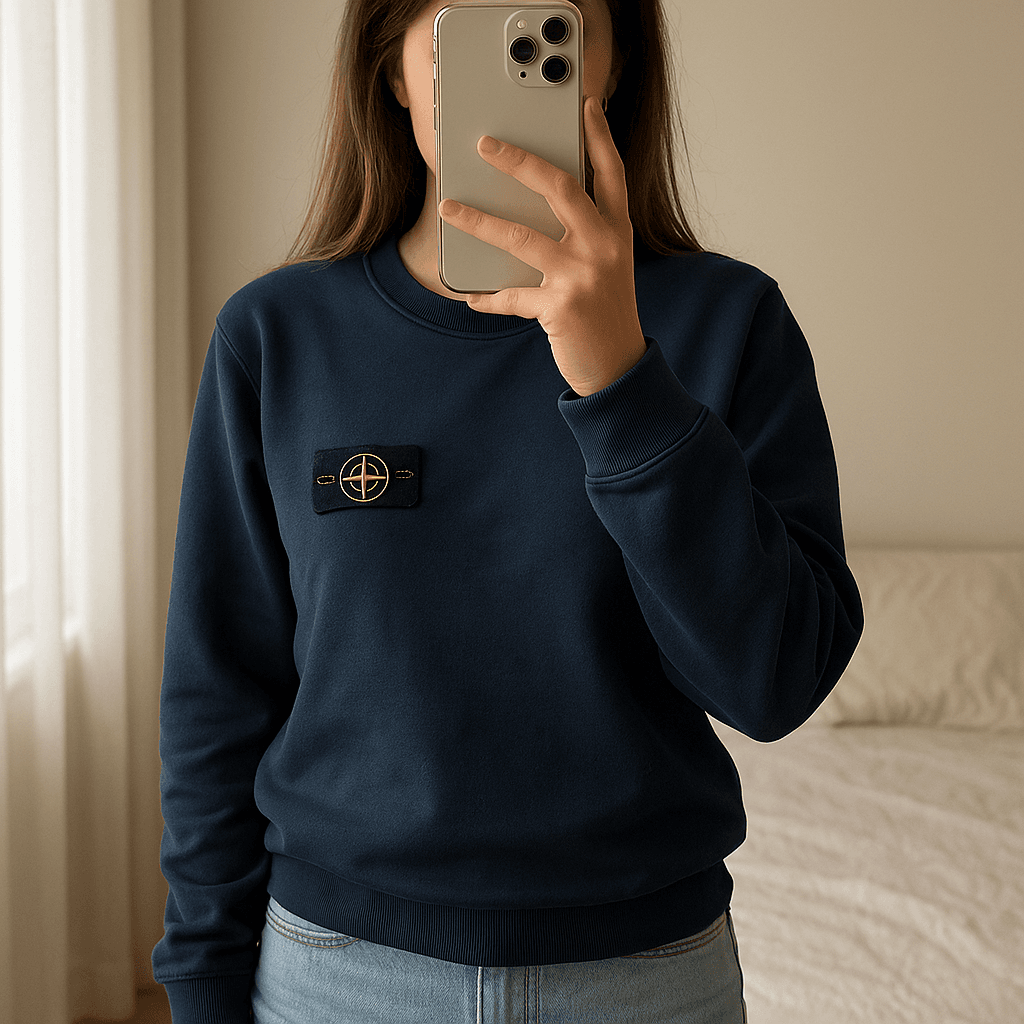 Sweat Stone island Bleu Marine debout, face à la caméra, dans une chambre à la lumière douce, avec une lumière naturelle filtrant par la fenêtre.