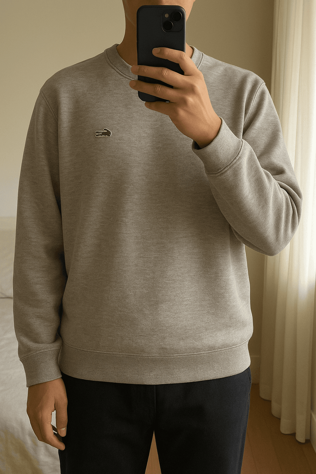 Original Lacoste Pullover aufrecht stehend, der Kamera zugewandt, in einem sanft beleuchteten Schlafzimmer, mit natürlichem Licht, das durch ein Fenster fällt.