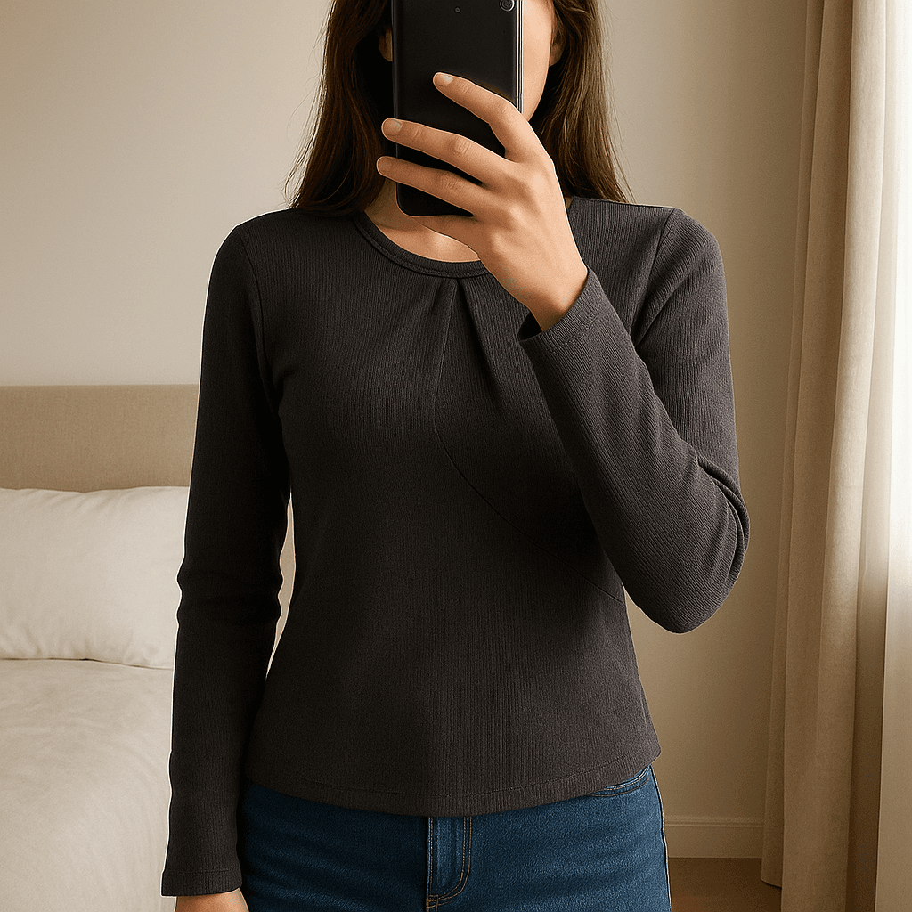 Camisola preta da bershka em pé, de frente para a câmera, em um quarto com iluminação suave e luz natural filtrando pela janela.