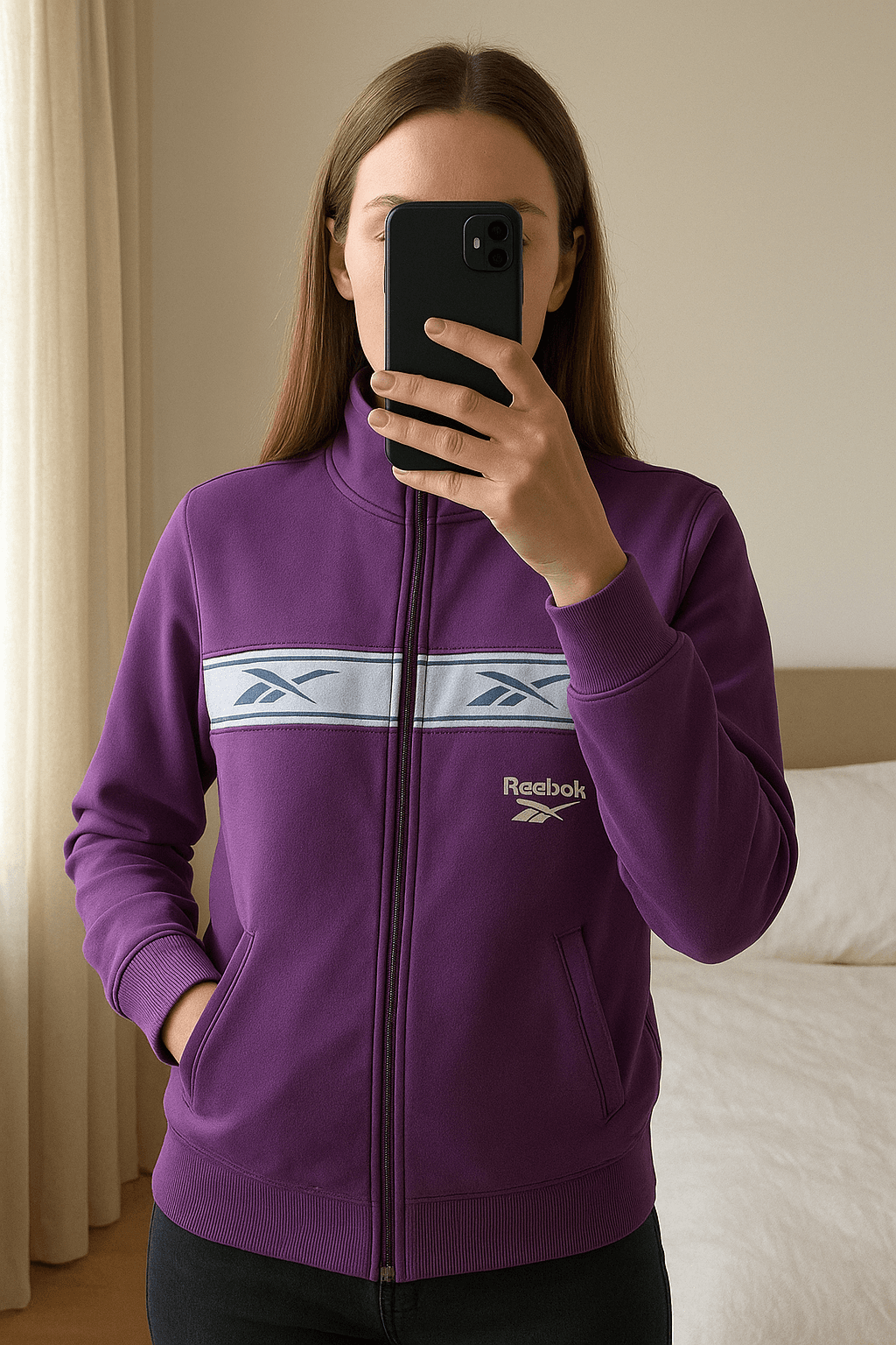 Reebok Jacke Retro Lila aufrecht stehend, der Kamera zugewandt, in einem sanft beleuchteten Schlafzimmer, mit natürlichem Licht, das durch ein Fenster fällt.