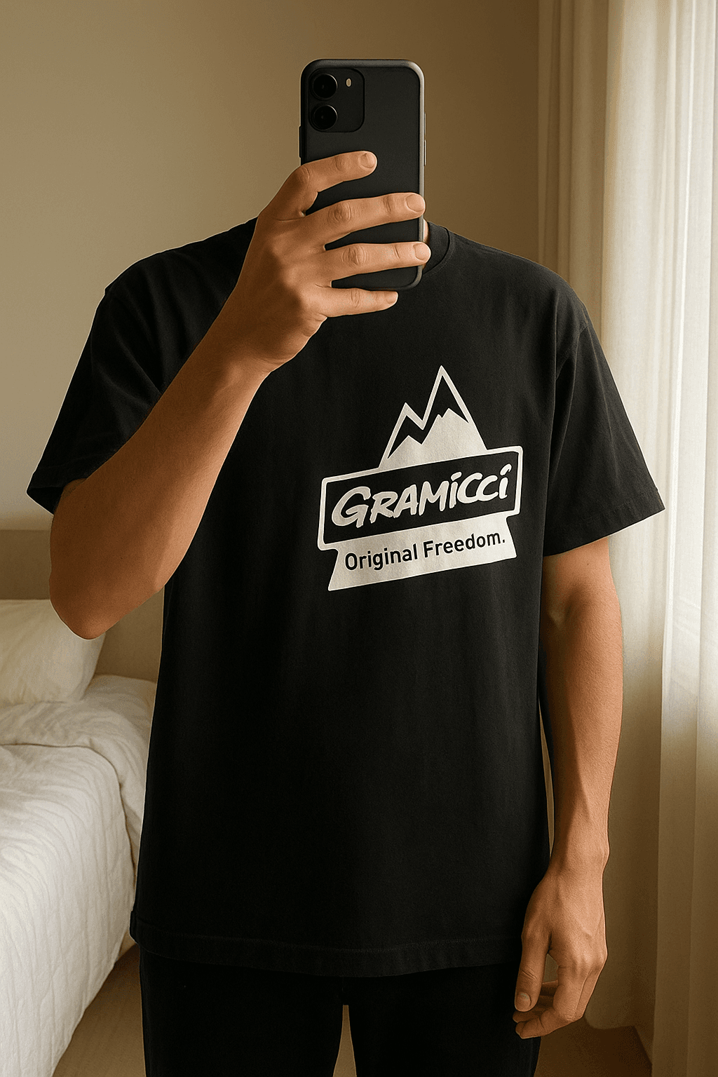 Gramicci T-Shirt aufrecht stehend, der Kamera zugewandt, in einem sanft beleuchteten Schlafzimmer, mit natürlichem Licht, das durch ein Fenster fällt.