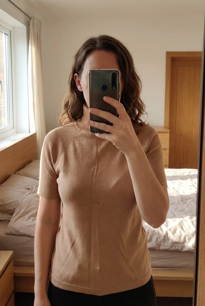 Nieuwe Coltrui beige - Sfera - Maat S - nooit gedragen debout, face à la caméra, dans une chambre à la lumière douce, avec une lumière naturelle filtrant par la fenêtre.