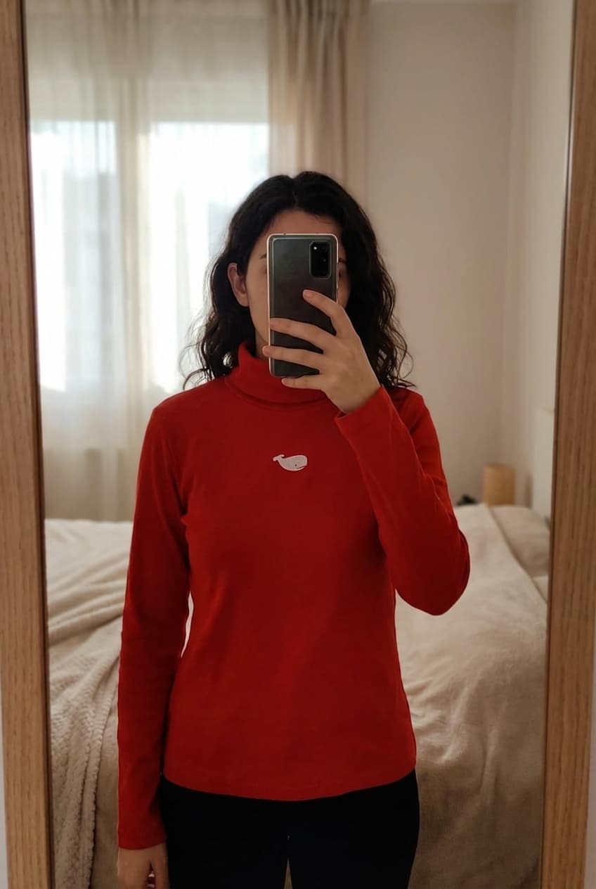 Rode coltrui - Le phere de la baleine - maat S - als nieuw debout, face à la caméra, dans une chambre à la lumière douce, avec une lumière naturelle filtrant par la fenêtre.