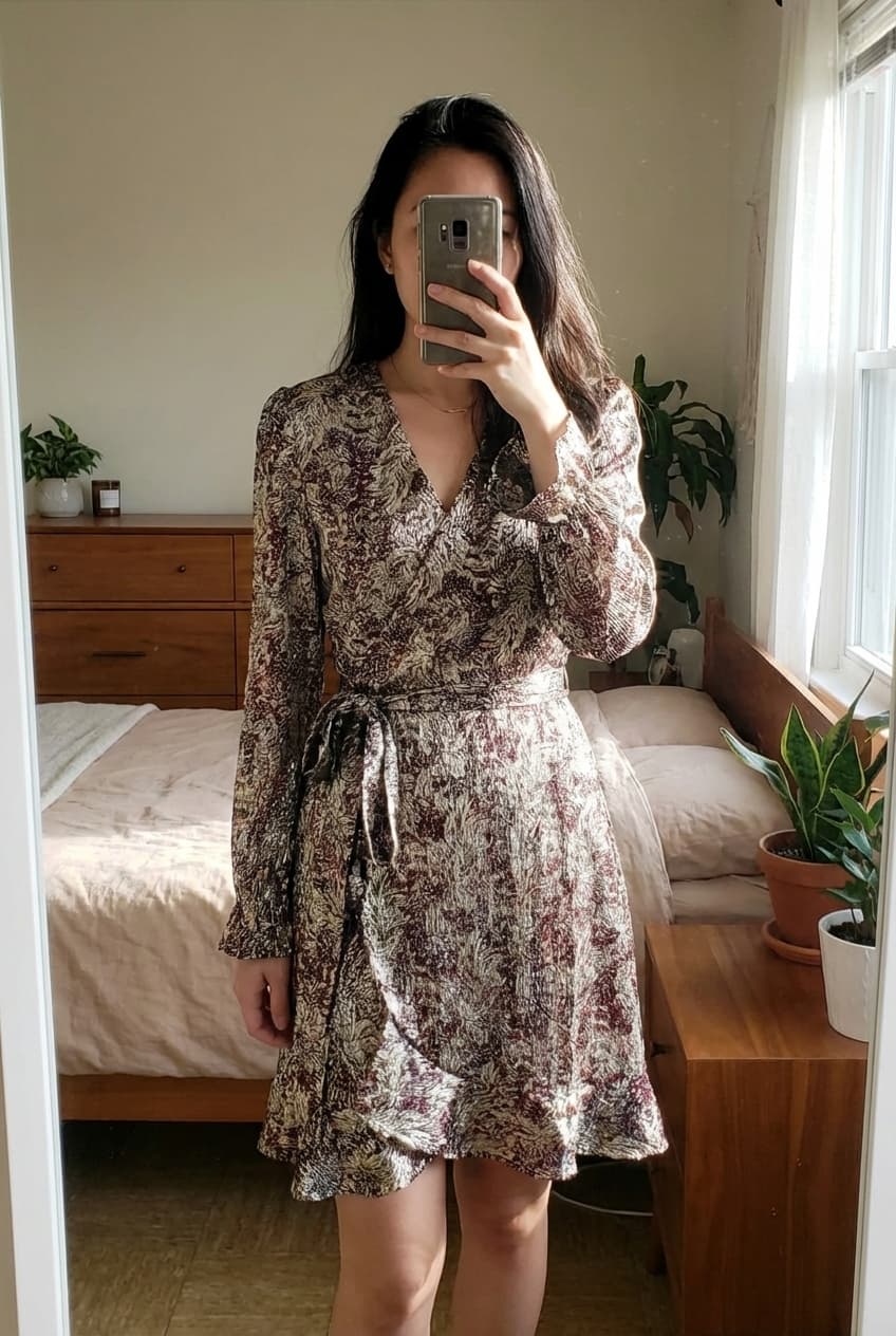 Jolie robe porte feuille debout, face à la caméra, dans une chambre à la lumière douce, avec une lumière naturelle filtrant par la fenêtre.