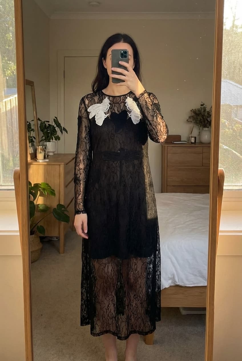 Robe très chic debout, face à la caméra, dans une chambre à la lumière douce, avec une lumière naturelle filtrant par la fenêtre.