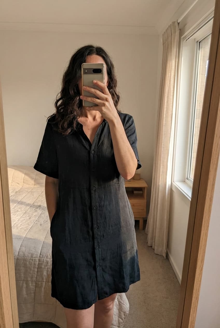 Robe Zara debout, face à la caméra, dans une chambre à la lumière douce, avec une lumière naturelle filtrant par la fenêtre.