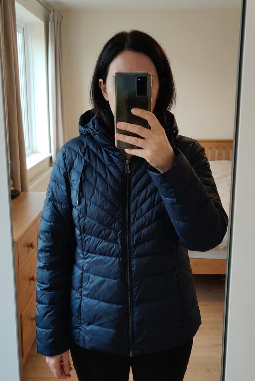 Zo goed als nieuwe gewatteerde jas - Terre Bleue - Maat 40 debout, face à la caméra, dans une chambre à la lumière douce, avec une lumière naturelle filtrant par la fenêtre.