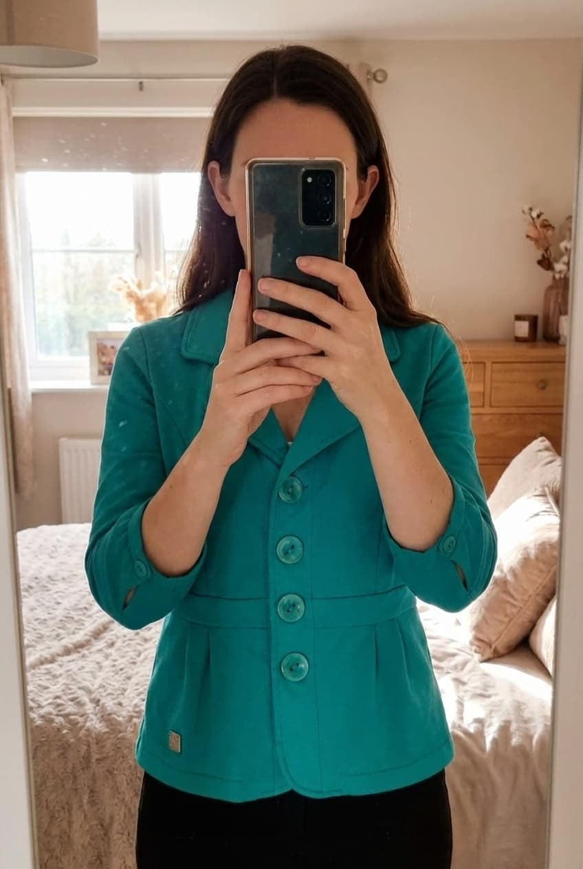 Turquoise vest - Xandres - S - als nieuw debout, face à la caméra, dans une chambre à la lumière douce, avec une lumière naturelle filtrant par la fenêtre.